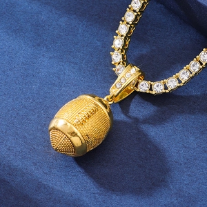 Close-up of golden rugby pendant with iced-out diamond chain on blue velvet