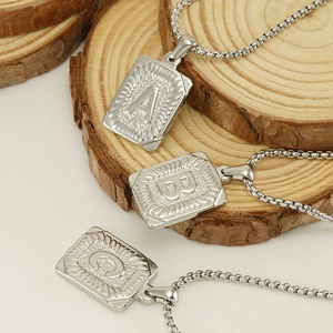 Square stainless steel alphabet pendant necklaces A B C on natural wood block