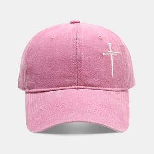 Detail der rosa gewaschenen Baumwoll-Basecap mit weißer Kreuz-Stickerei Textur
