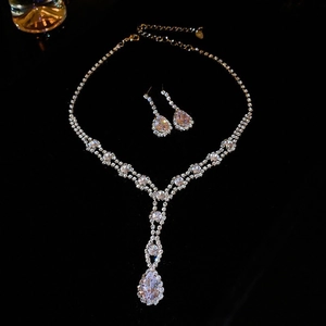 Detail of silver-tone floral crystal necklace and matching earrings on a black background