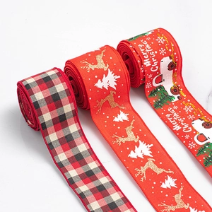 Detail of Christmas ribbons featuring red plaid, golden reindeer, and Santa truck prints