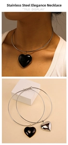 Detail view of heart-shaped stainless steel choker necklace on model and product stand