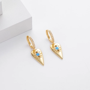 Detail of gold heart and evil eye earrings with blue opal and white cubic zirconia