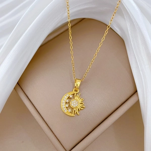 Macro shot of gold celestial necklace with sparkling rhinestones on sun moon pendant