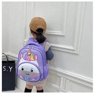 Back view of a girl wearing a purple cartoon unicorn backpack with rainbow mane detail