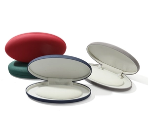 Detailed view of four oval velvet jewelry boxes in red, green, blue and grey finishes