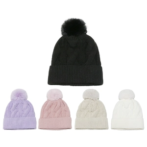 Close-up of cable-knit beanies with faux fur pom-poms in various pastel and neutral colors