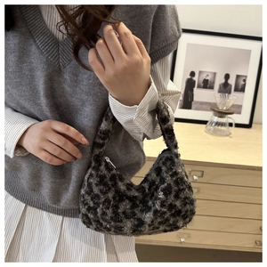 Detailed close-up of leopard print faux fur texture and zipper on the crescent handbag