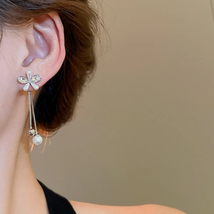 Detail of silver tassel earrings with sparkling crystals and a white pearl drop