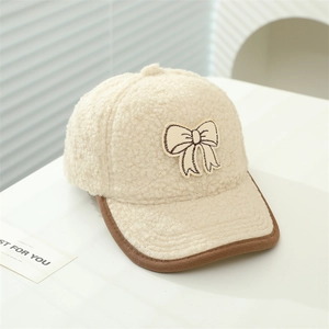 Detail der beigen Fleece-Baseballkappe mit Schleifenbestickung und Kontrastpaspelierung