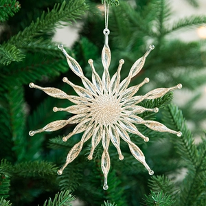 Flocon de neige étincelant en résine champagne doré suspendu à un sapin de Noël vert