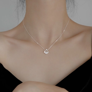Elegant silver circle necklace with sparkling center stones worn on a model's collarbone