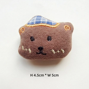 Close-up of brown plush bear accessory with blue plaid bow, size 4.5cm by 5cm