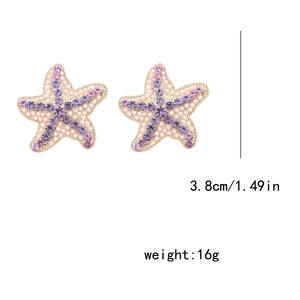 Détail de boucles d'oreilles étoile de mer avec strass violets et taille 3,8cm