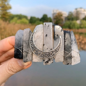 Detail of bohemian moon hair clip with natural rutilated quartz and silver wire wrap