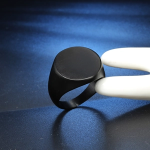 Minimalist black matte titanium steel signet ring for men on a blue background