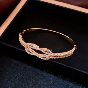 Bracelet entrelacé plaqué or 18 carats serti de zircons sur écrin en velours noir
