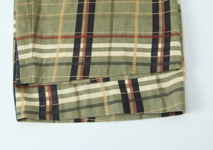 Gros plan du pantalon en lin à carreaux montrant la texture et la finition de l'ourlet