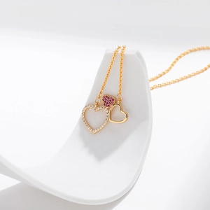 Three linked heart pendant necklace in gold finish with sparkling white and pink crystals