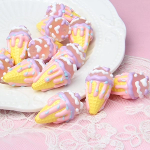 Close-up of colorful acrylic ice cream beads for DIY jewelry and phone charms on lace