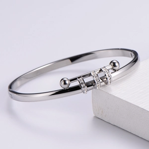 Detailed view of silver titanium steel bangle with pave zircon accents and spherical ends