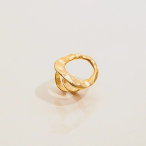 Détail de la texture martelée en or 18k sur la bague ouverte en acier inoxydable poli