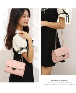 Detailed view of pink quilted crossbody bag with gold chain strap and stitching