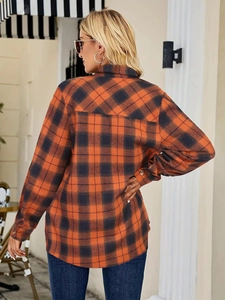 Detail of classic orange and black plaid shirt showing back view and buttoned sleeve cuffs