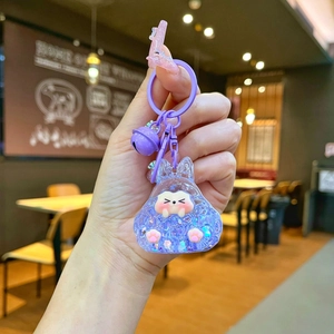 Detail of purple rabbit liquid sand keychain with glitters, bell and acrylic ring