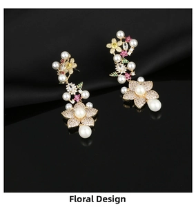 Detail of floral drop earrings with multicolored zircons and white pearls on black silk