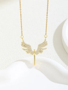 Macro shot of a gold angel wing pendant necklace with pavé cubic zirconia inlay