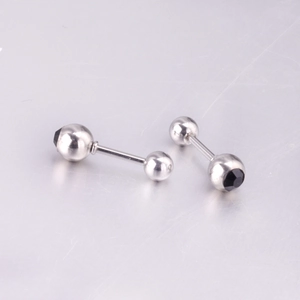 Macro shot of a stainless steel barbell stud earring featuring a black faceted gemstone