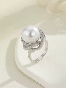 Detail eines weißen Perlenrings mit Zirkonia-Mikropflaster in floraler Fassung