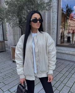 Detail of off-white oversized bomber jacket with quilted lining and ribbed cuffs