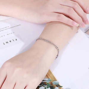 Double-layered silver bead chain bracelet on wrist with a minimalist fashion style