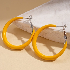 Detailed close-up of chunky bright yellow enamel hoop earrings with silver-tone pins