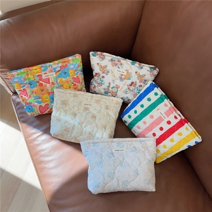 Quilted cotton cosmetic bags with cute bear and floral patterns on a leather sofa