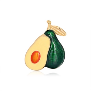Macro detail of avocado brooch featuring gold-plated metal and polished enamel finish