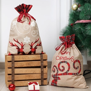 Detail of burlap Christmas gift bags with reindeer embroidery and plaid patterns