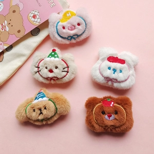 Five assorted cute cartoon plush animal pins with embroidery on a soft pink background