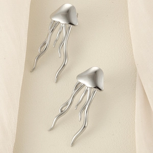 Macro detail of silver jellyfish earrings with sleek tentacles and polished metal finish