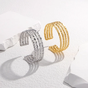 Detailed macro view of gold and silver textured stainless steel multi-layer open bracelets