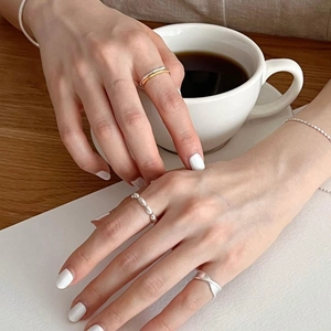 Detail of 925 sterling silver bamboo style rings and bead bracelet on a model hand