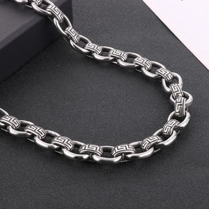 Macro detail of 12mm stainless steel chain links with engraved Greek Key patterns