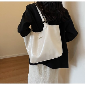 Back view of a model wearing a high-gloss white leather tote bag for professional look