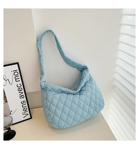 Detail of light blue quilted puffer shoulder bag featuring diamond lattice stitching