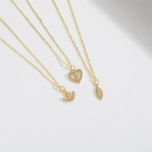 Detailed view of three gold vintage religious charms with micro zircon pavé edges