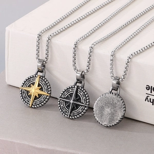 Detailed macro view of vintage stainless steel compass pendants in silver and gold finishes