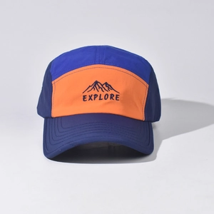 Detailed close-up of mountain peak embroidery and EXPLORE text on a cotton baseball cap