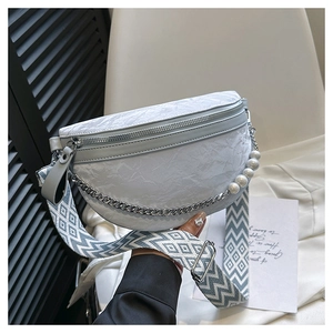 Detail of light blue crescent bag with silver chain, pearl accent and patterned strap